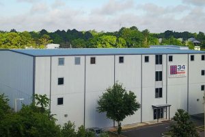 Modern white building with trees and a partly cloudy sky.