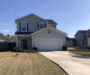 Two-story suburban house with a double garage and a clean driveway.