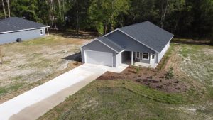 Newly built modern house with a two-car garage and landscaped yard.