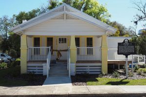 Small yellow house with white trim and front porch.