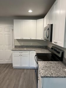 Modern kitchen with white cabinets and granite countertops.